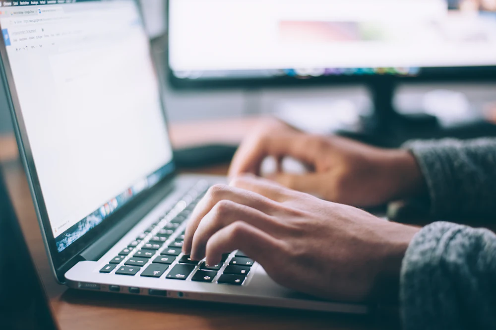 Content creator writing a blog post on a laptop